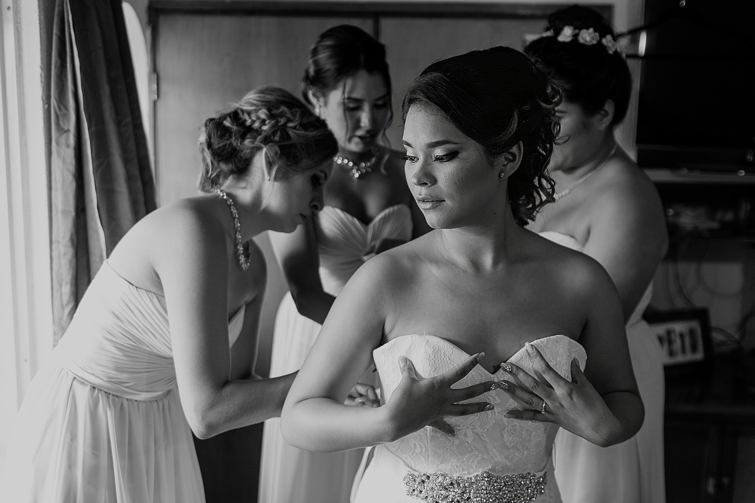 Damas ayudando a la novia a ponerse su vestido