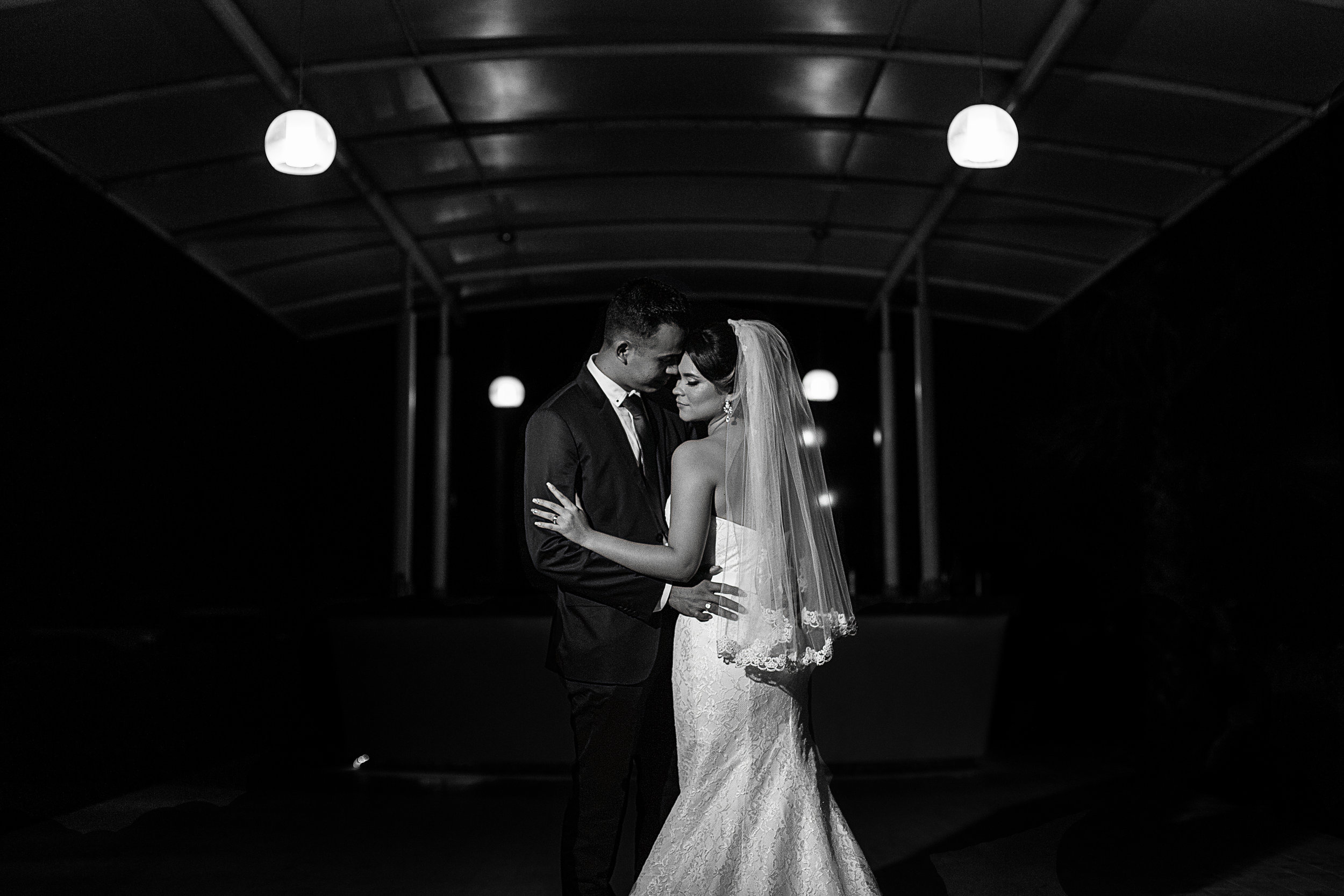 Retrato de pareja en el día de su boda, novia y novio parados frente a frente abrazados