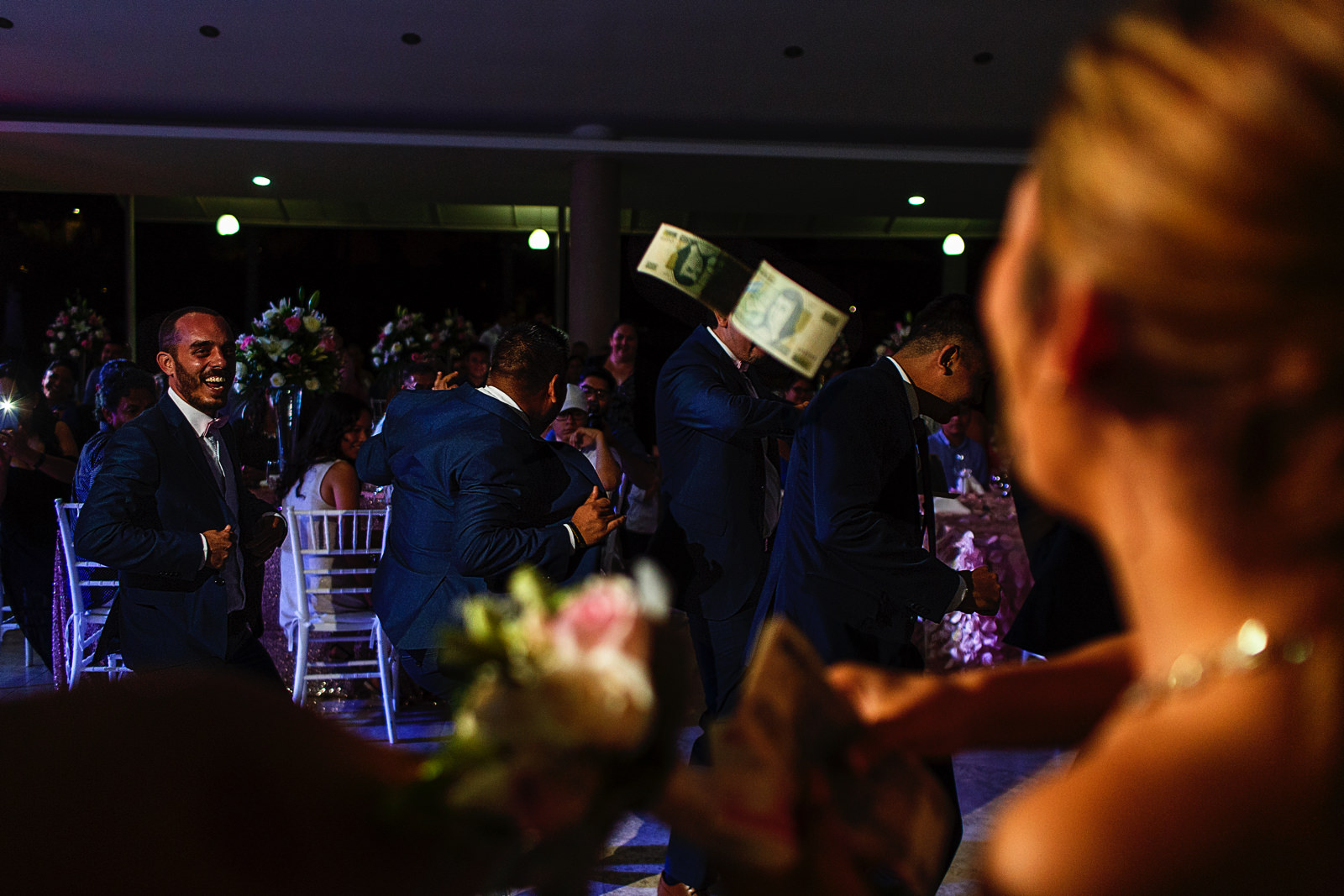 Las damas avientan billetes a los amigos del novio durante un pequeño baile como entretenimiento y presentación de la pareja en la fiesta de la boda