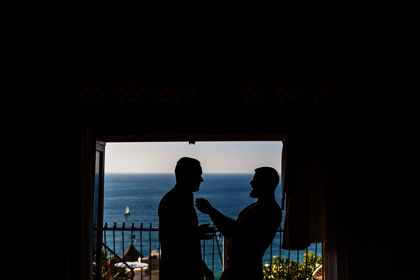 Silhouette of groom and best man getting ready for wedding ceremony