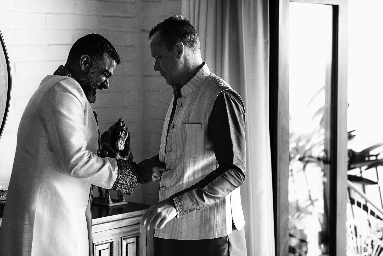 Groom and best man having fun while getting dressed