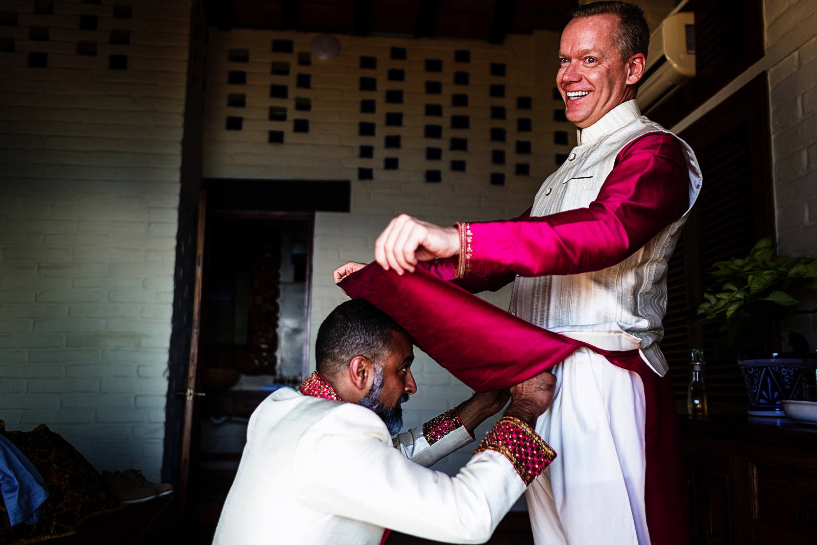 Groom helps best man to tie his pant