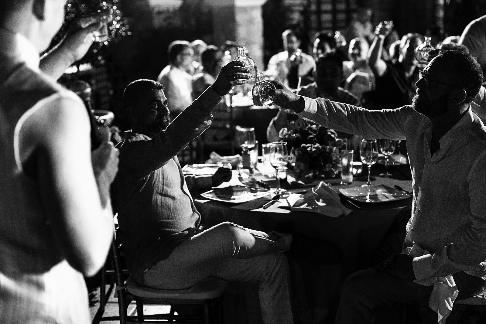 Groom and groom raise their bottle of tequila toasting on the best man speech