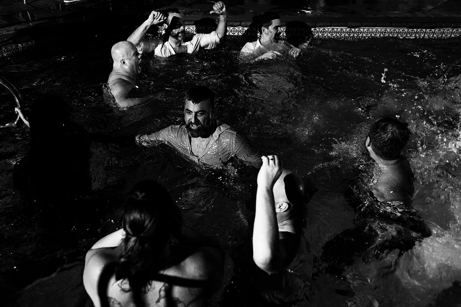 Groom and wedding guests continuing the party in the pool