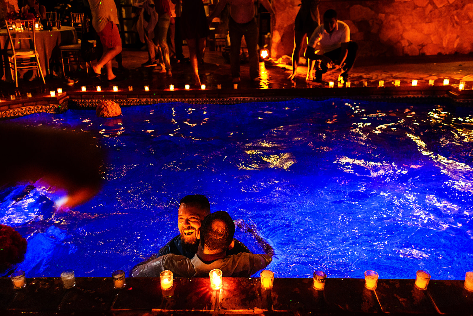 Wedding guest and groom hugging into the Casa Muni's pool