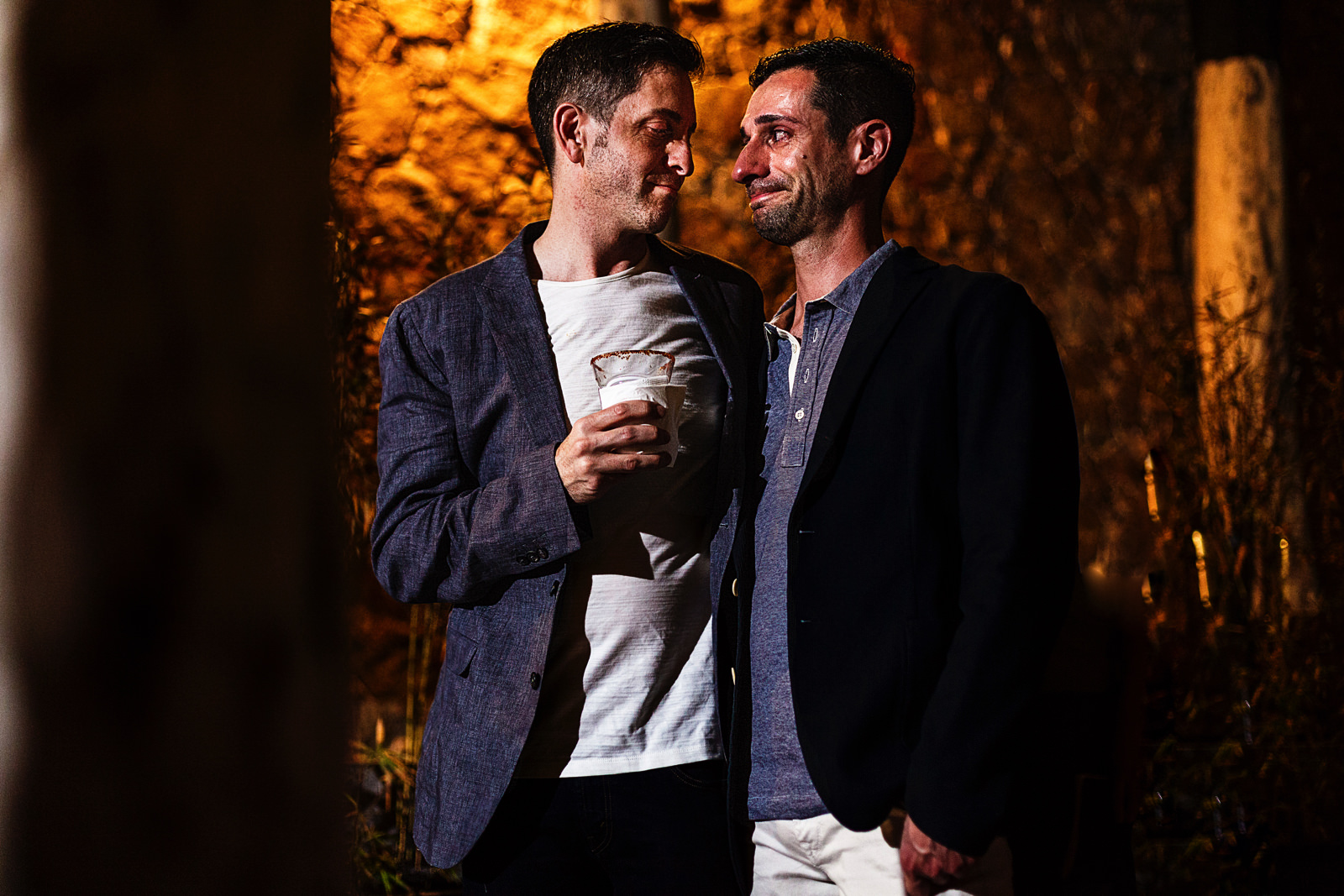 Gay couple reacting to the words said as part of the speeches during the rehearsal dinner