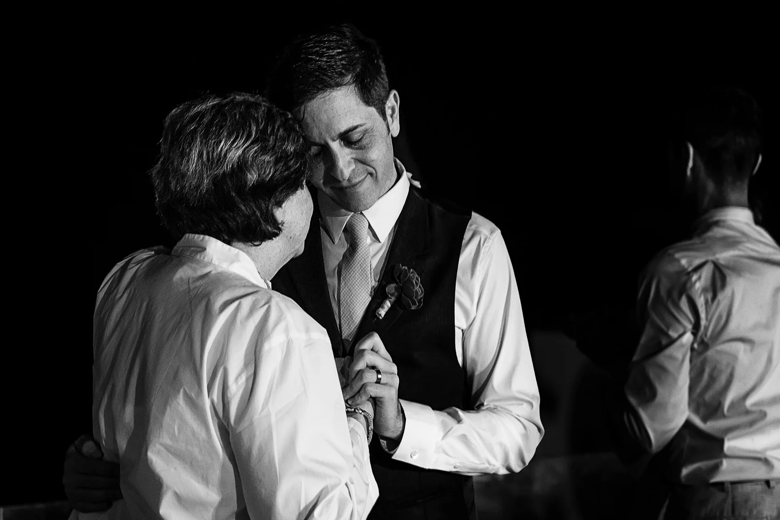 Groom dancing with his mother while gently smiles