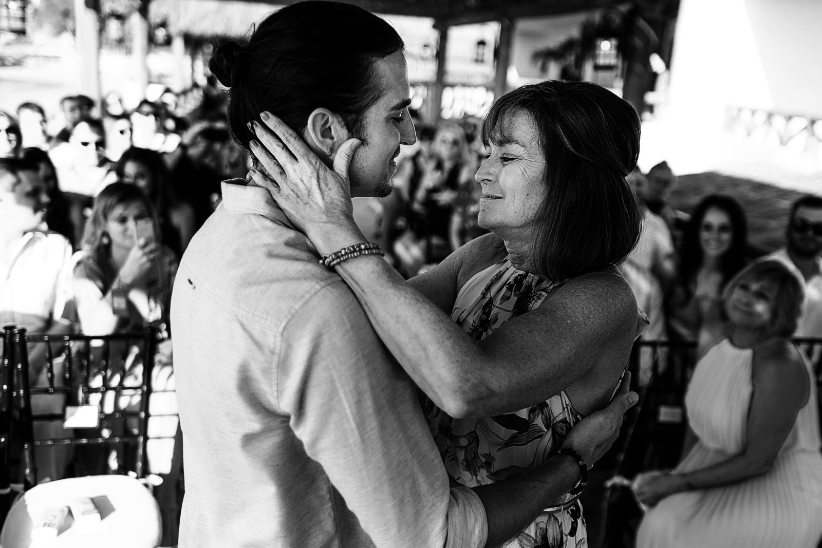 Mother of the groom hugging her son at the end of the aisle