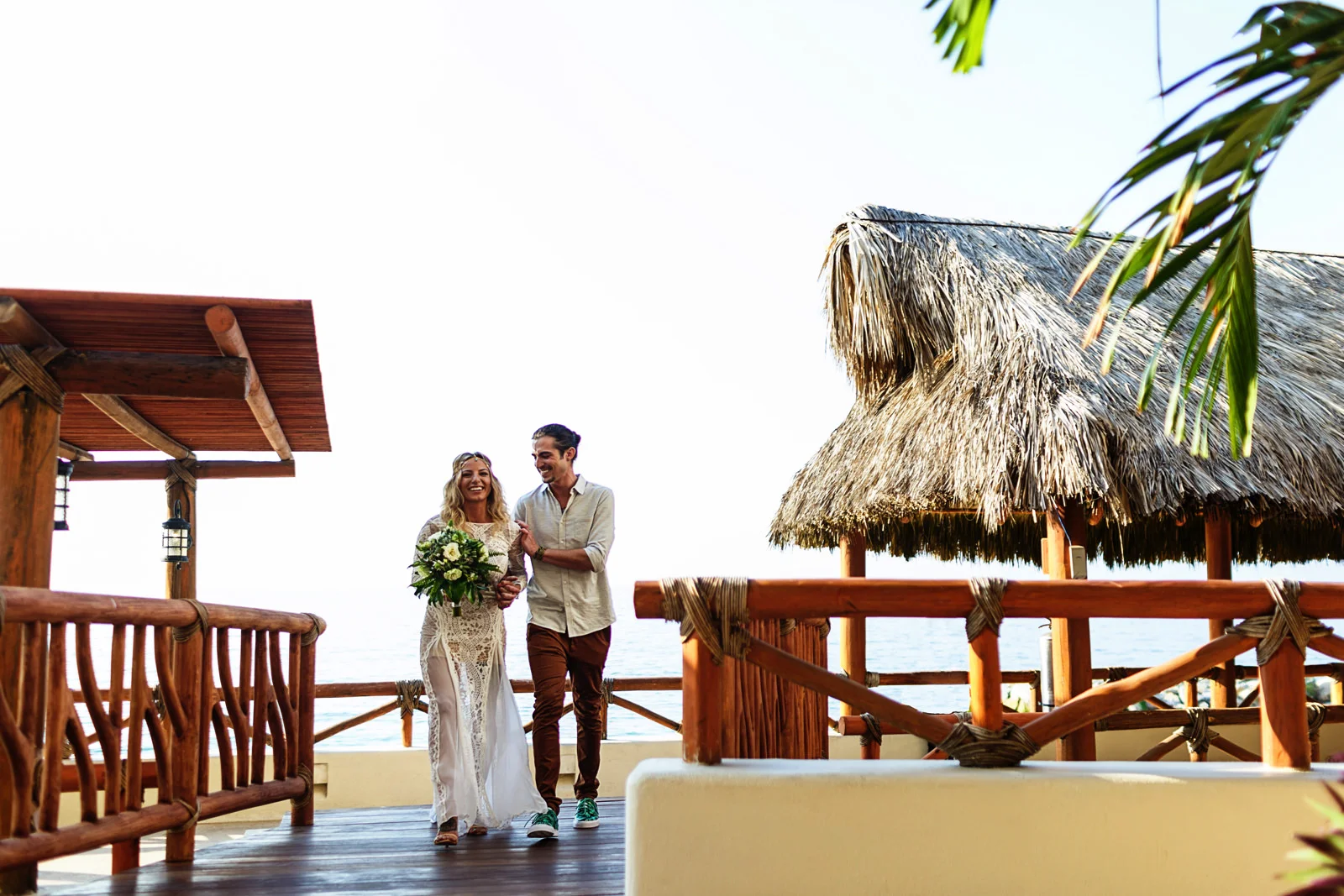 Wedding couple walking over a wooden bridge after their ceremony