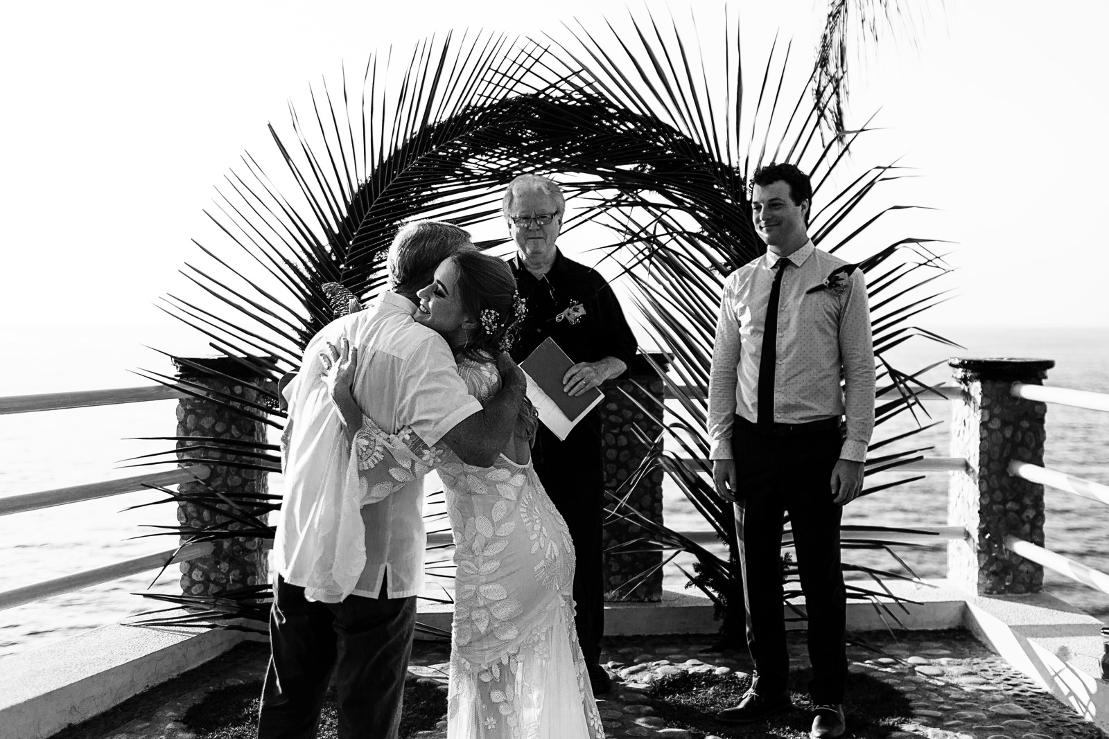 Bride and father hug as he gives her away at the end of the aisle before the wedding ceremony