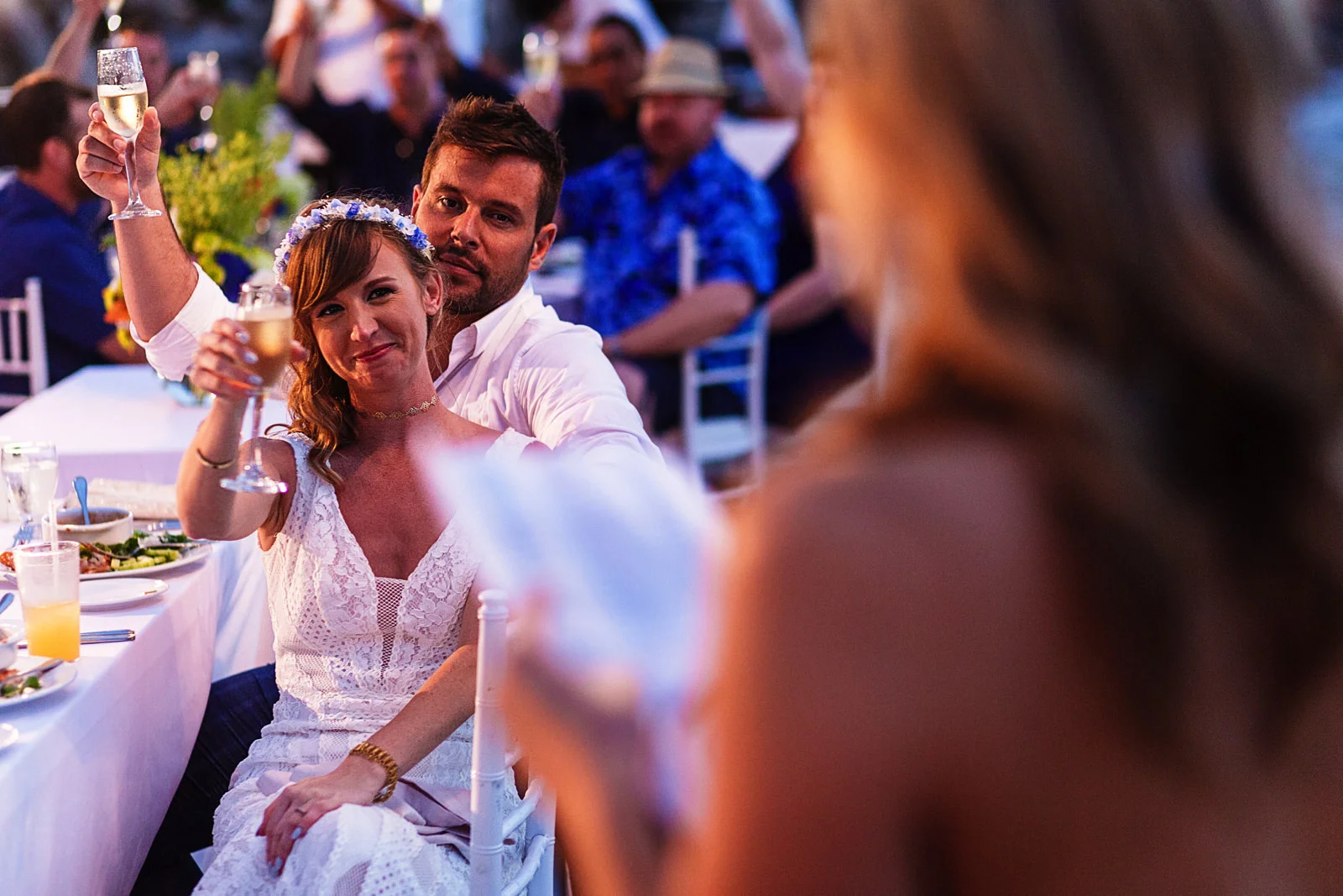 Groom and bride raise their glases filled with champagne at the end of the maid of honor's speech