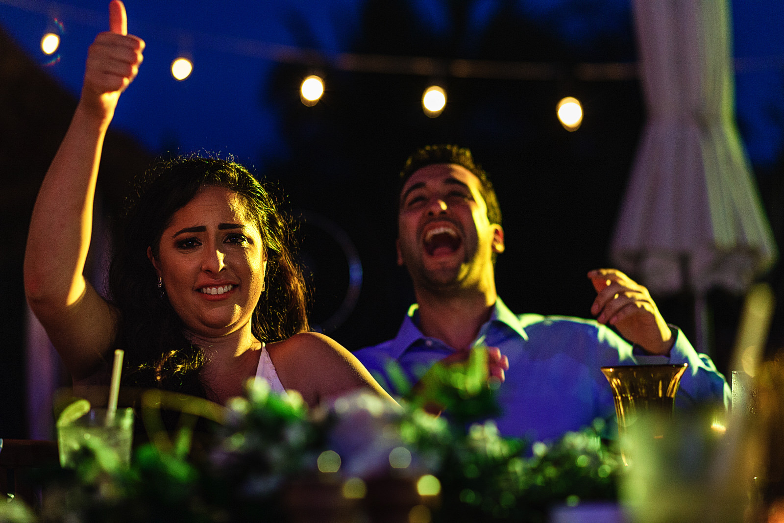 Groom and bride reacting during the speeches on the rehearsal dinner.