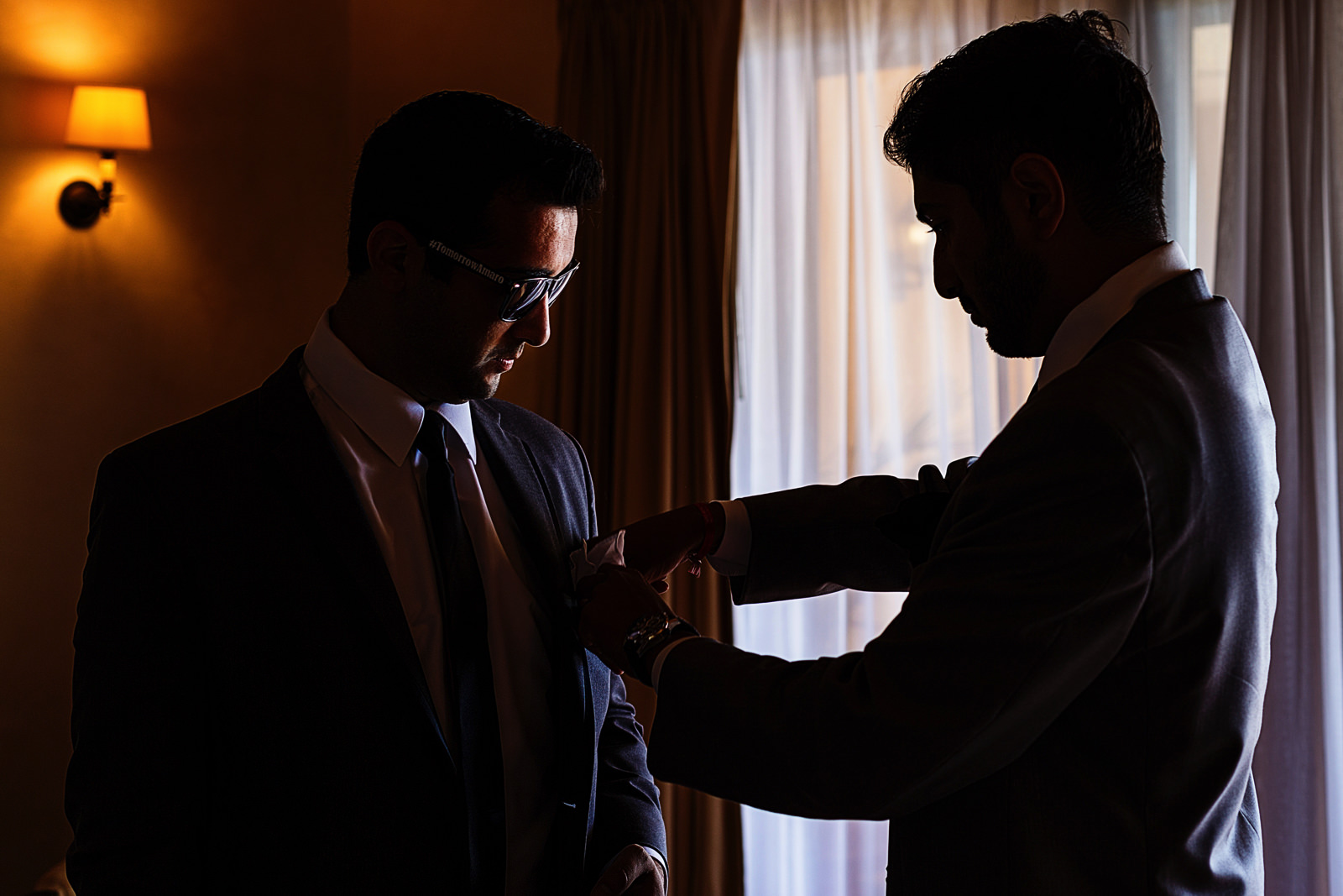 Groomsmen helping with handkerchief to the groom.