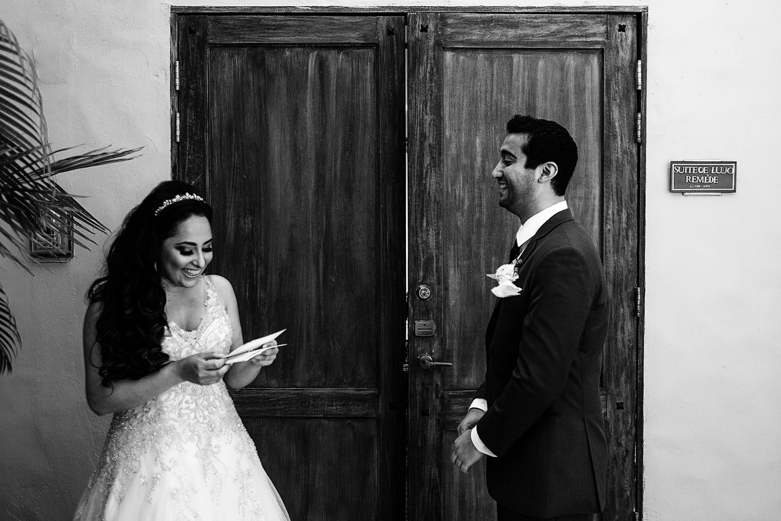 Bride reads a letter from the groom outside the bridal suite.