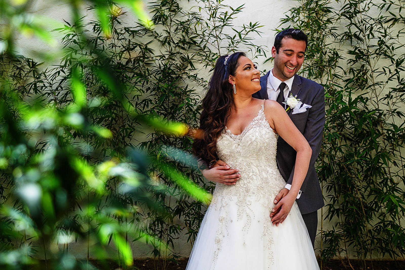 Groom and bride standing among bamboo plants on the spa halls of the St Regis Punta Mita resort.