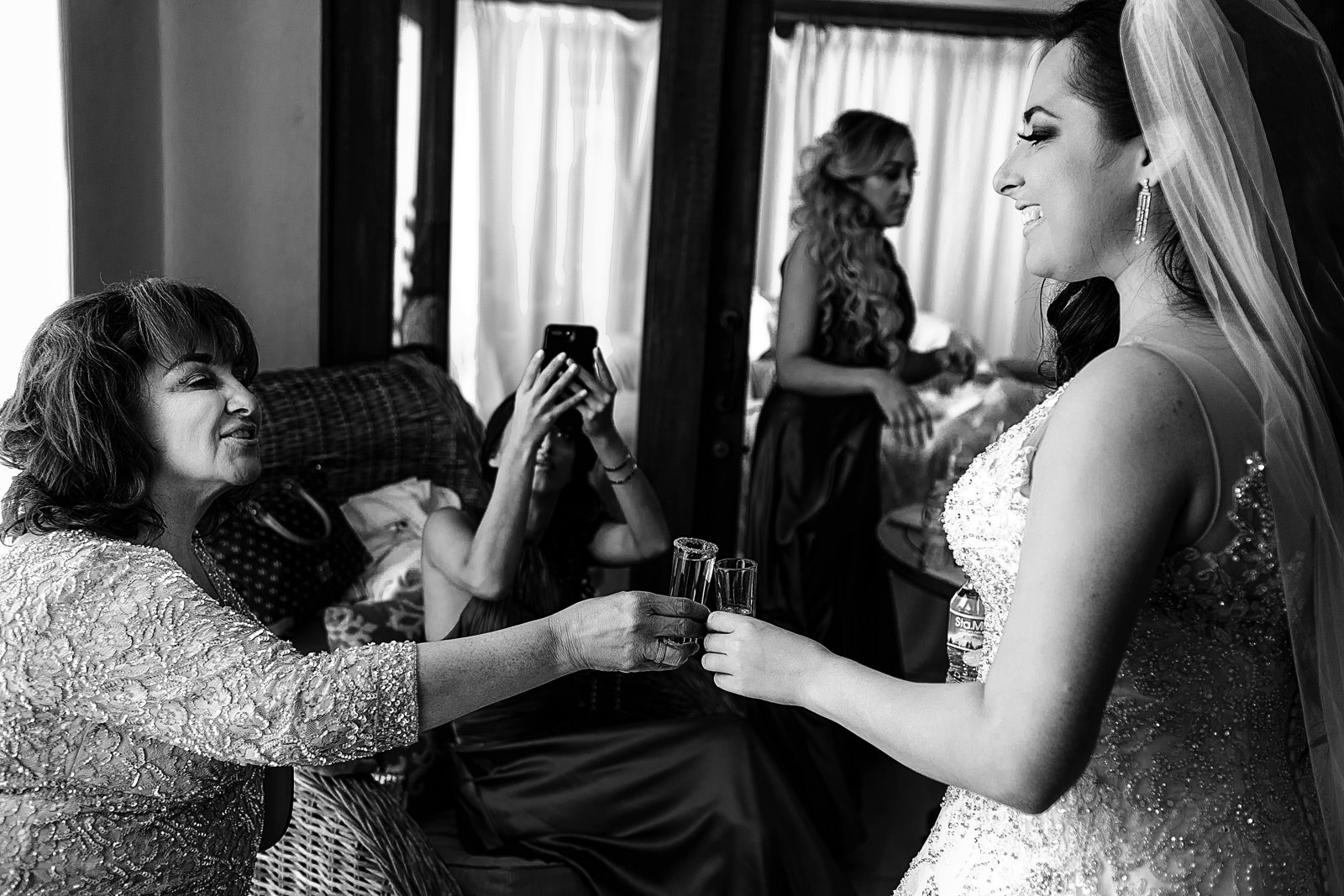 Bride and her mom toasting with tequila shots before the wedding ceremony at the bridal suite.