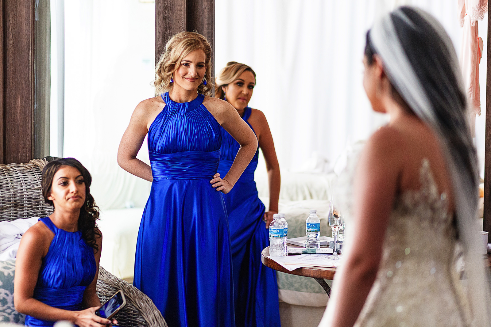 Bridesmaids stare at the fully dressed and ready-to-go bride.