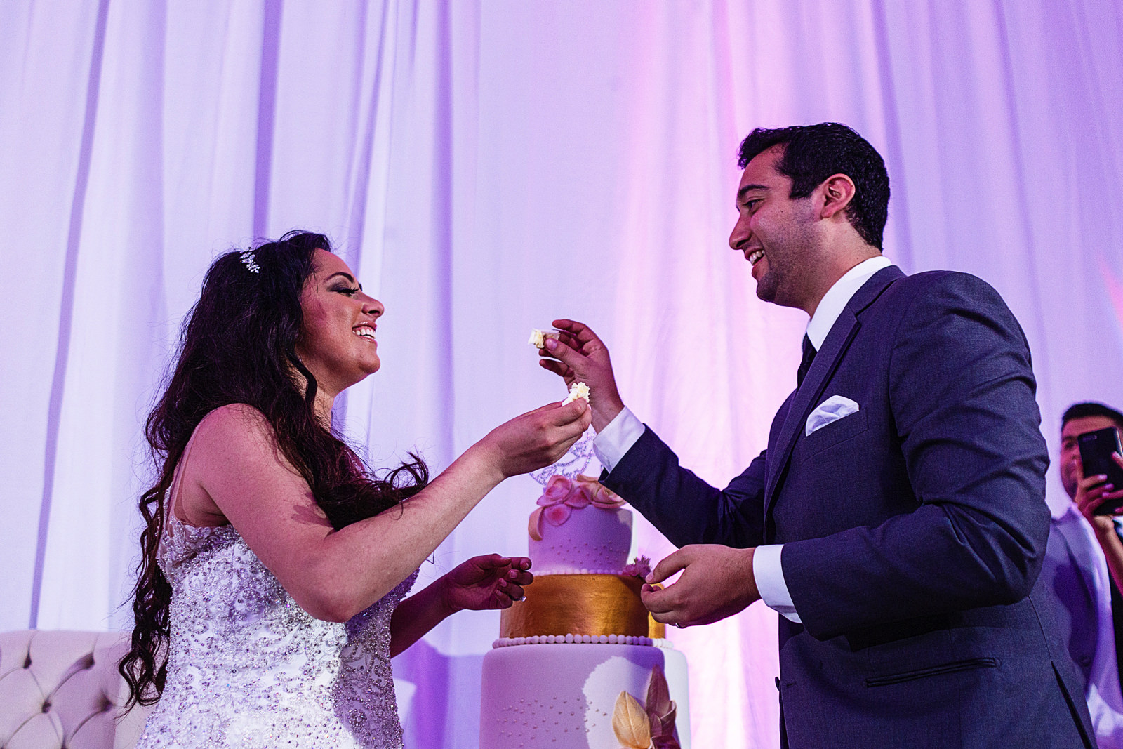 Groom and bride feeding each other cake.