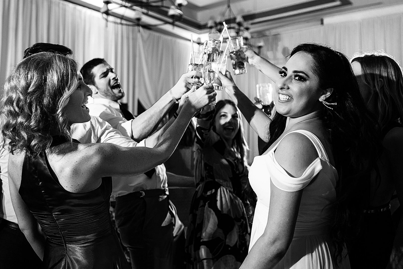 The bride toasts with friends on the dance floor.