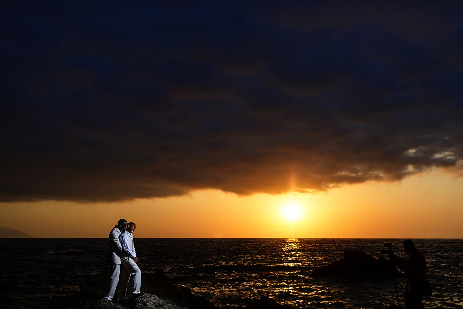 Beautiful sunset view from the rock at Casa Karma's beach, creative gay wedding portrait.
