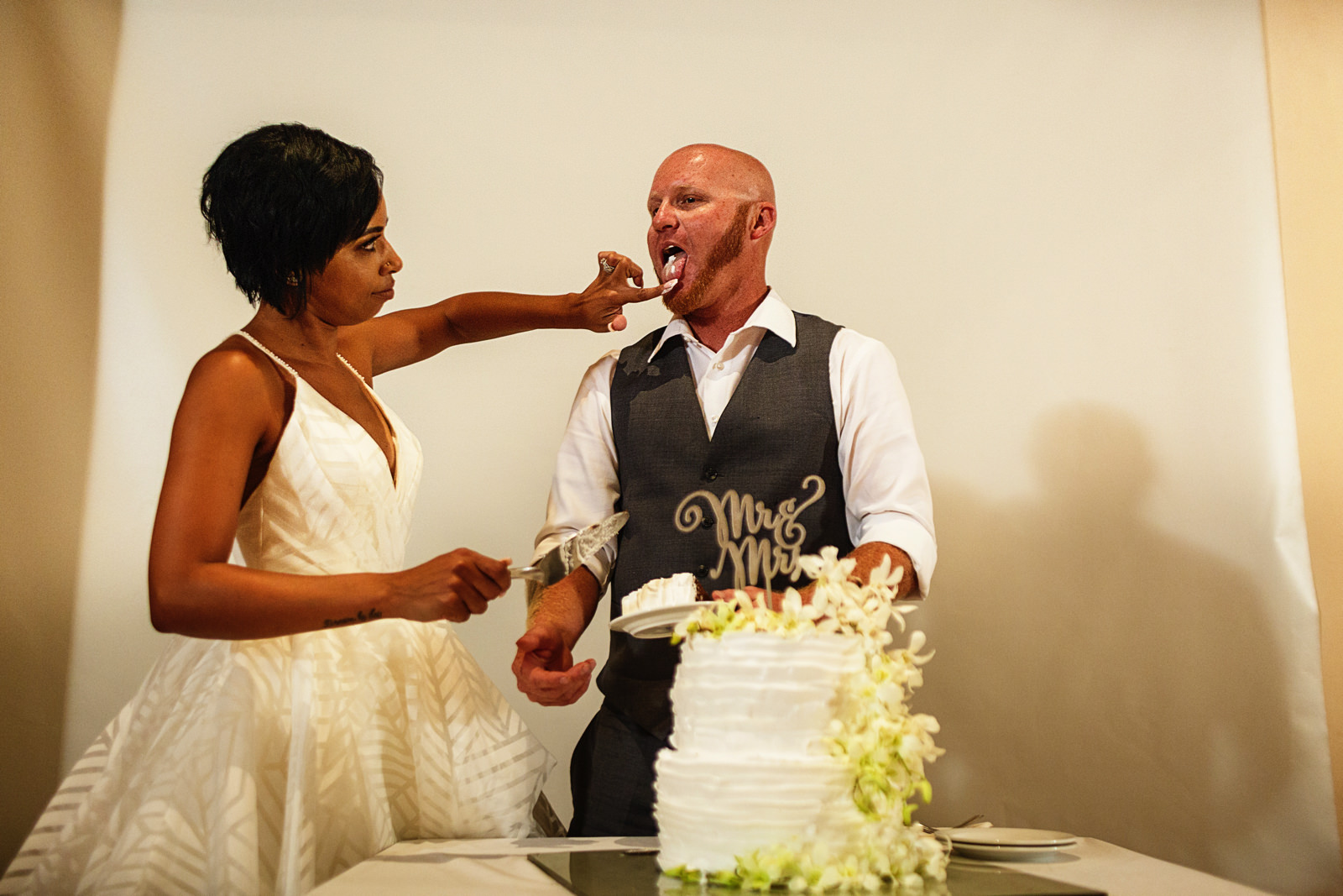 Bride feeds the groom with the cake's cream