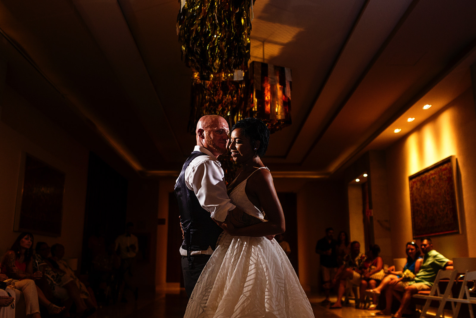 Bride and groom doing their first dance in front of all their friends and family