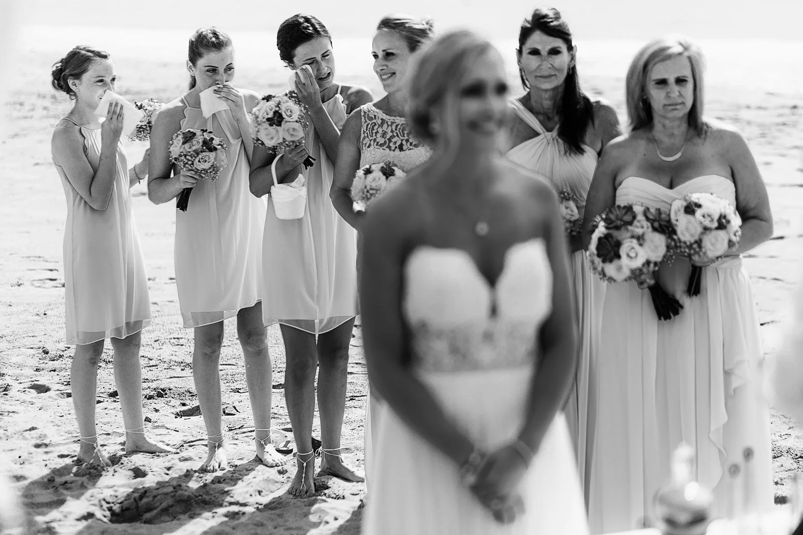 Daughters of the groom and bride crying behind their mom, ceremony on the beach of Mexico