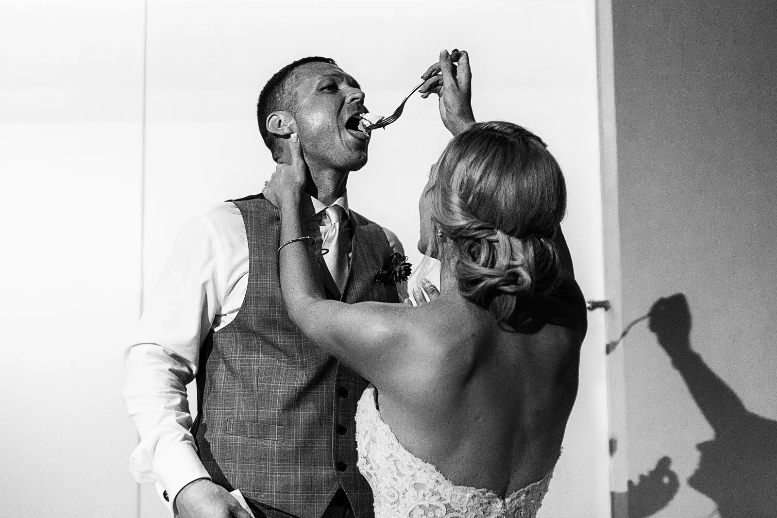 Bride force feed the groom with wedding cake