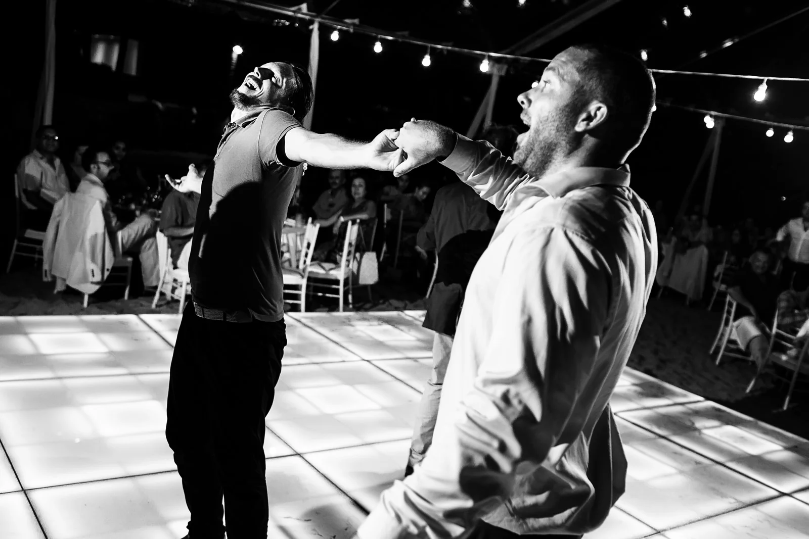 Two male friends dancing and swirling as the dance floor opens up