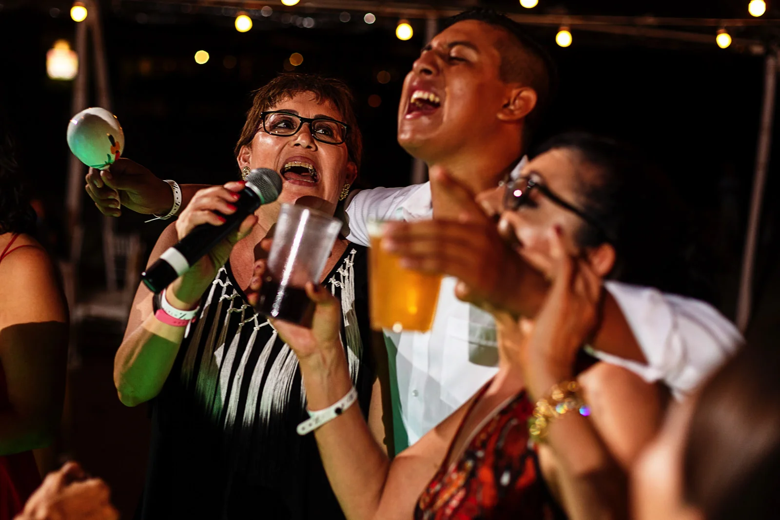 Wedding guests singing their butts off and holding drinks