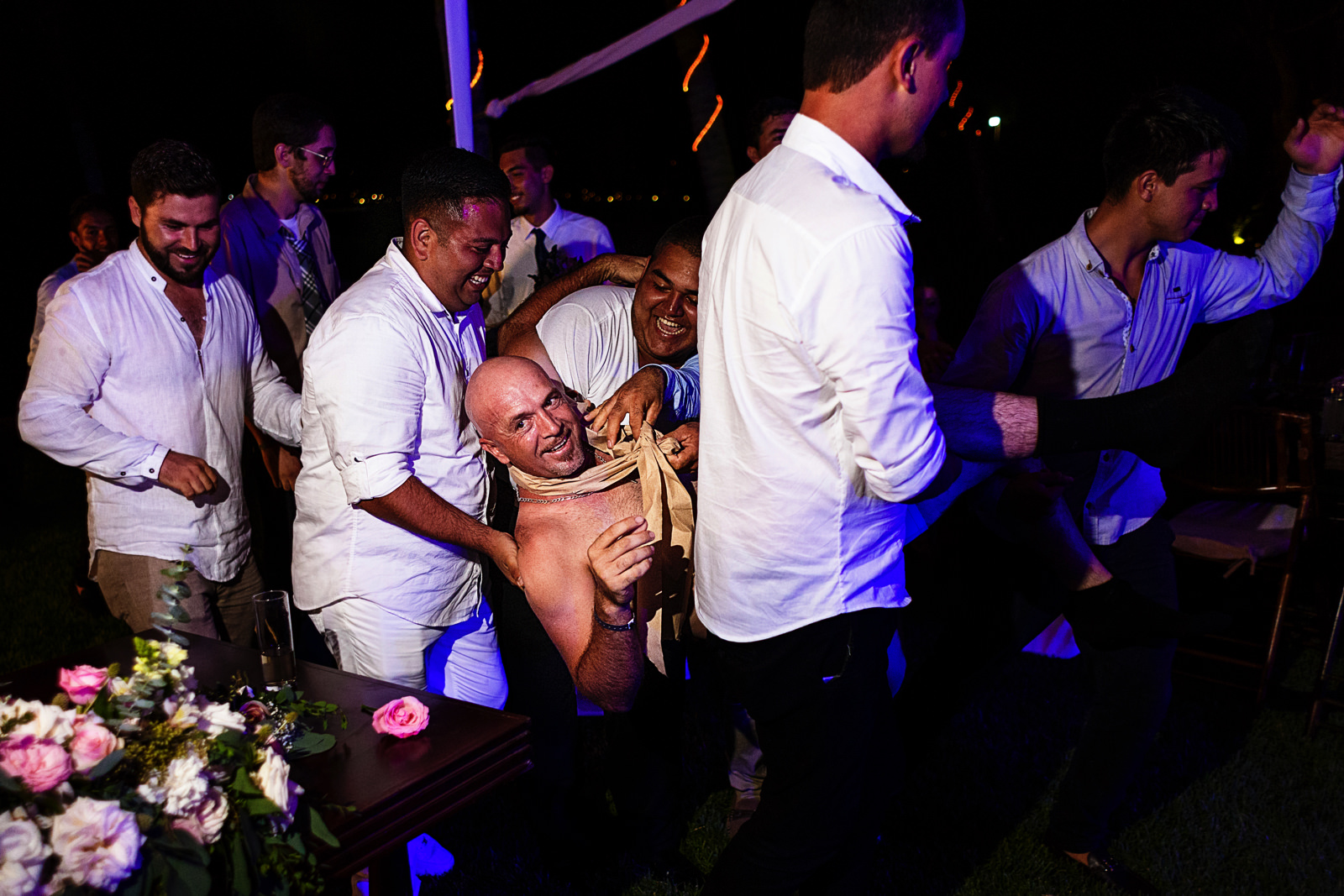 Novio es cargado por sus amigos y llevado a la pista de baile en ropa interior, en el día de su boda en la playa