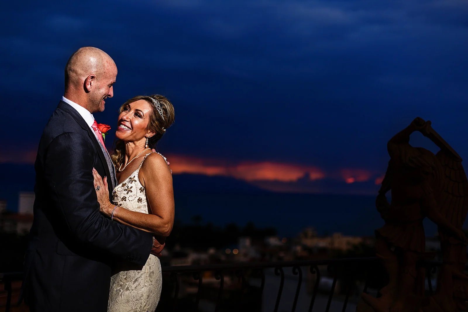 Wedding couple's portrait at the terrace of the bridal suite with a view of Puerto Vallarta in the sunset