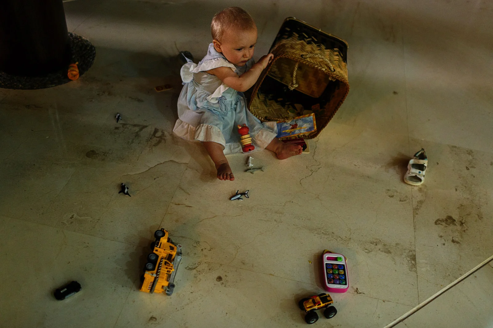 Baby girl making a mess with the basket of toys