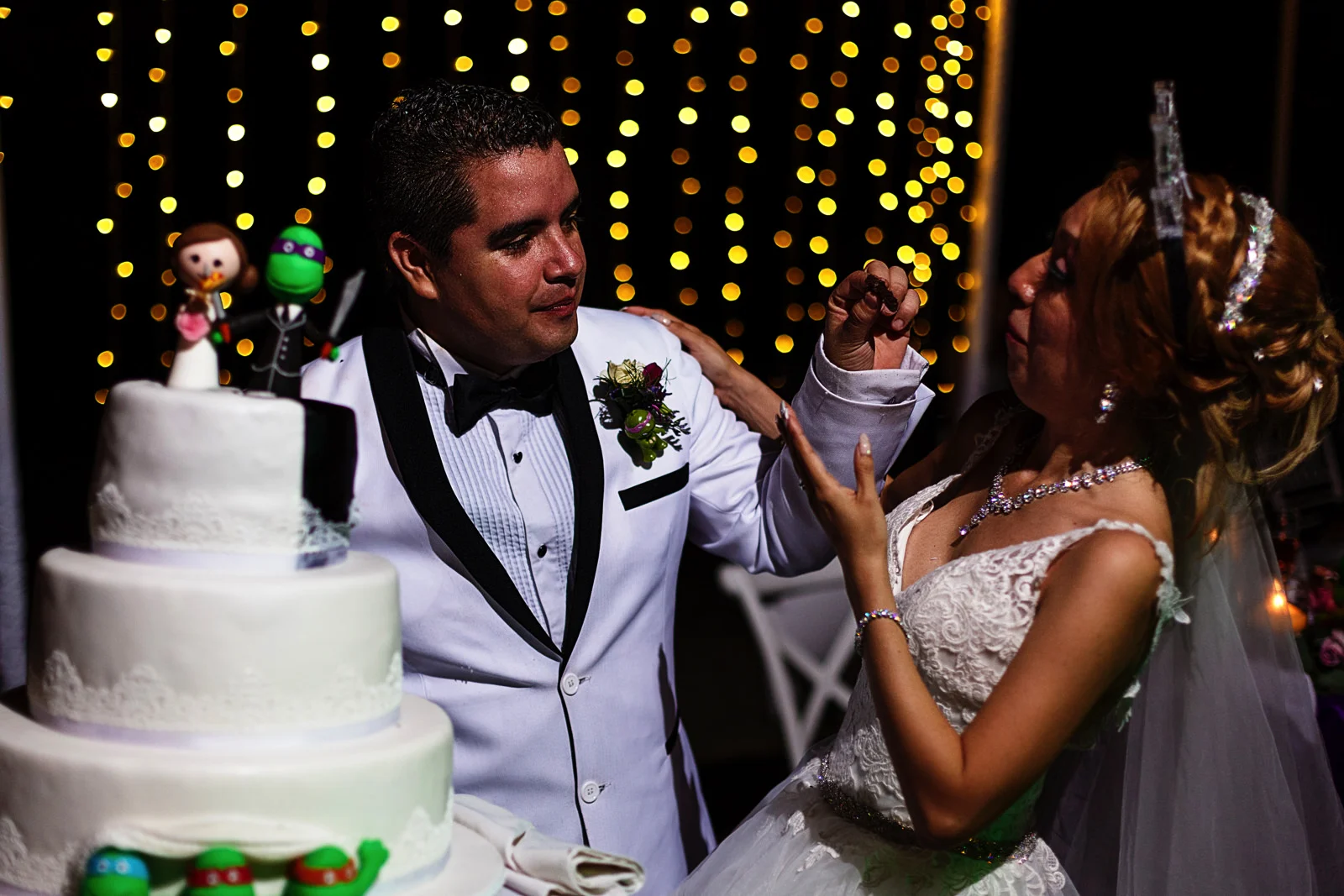 Groom and bride feeding the wedding cake to each other