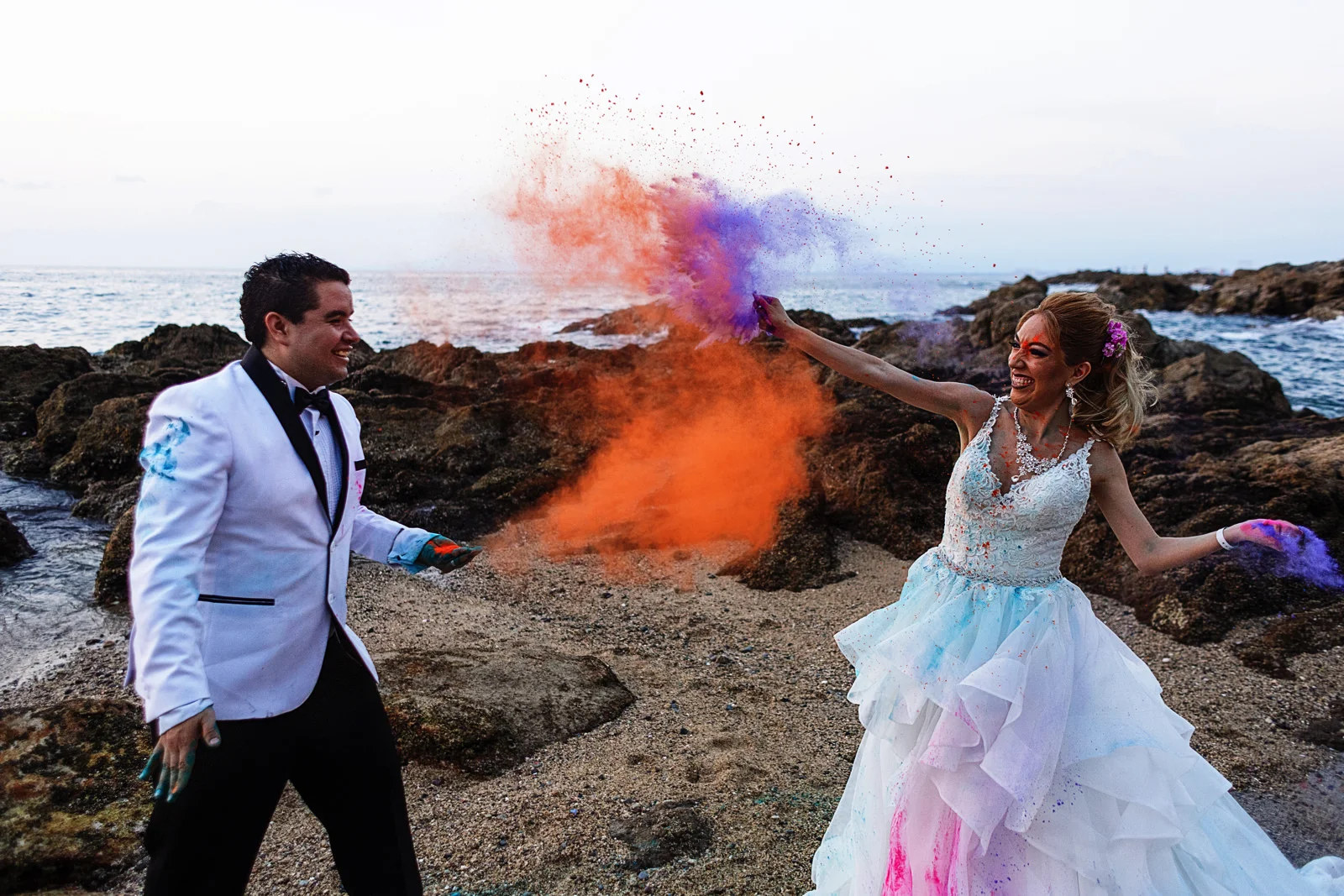 Groom and bride throw colorful holy powder to each other