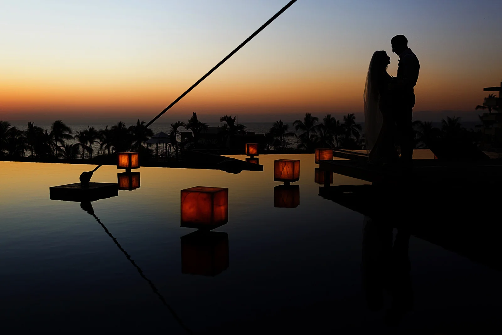 Silhouette of groom and bride at sunset on the Now Amber Puerto Vallarta platform
