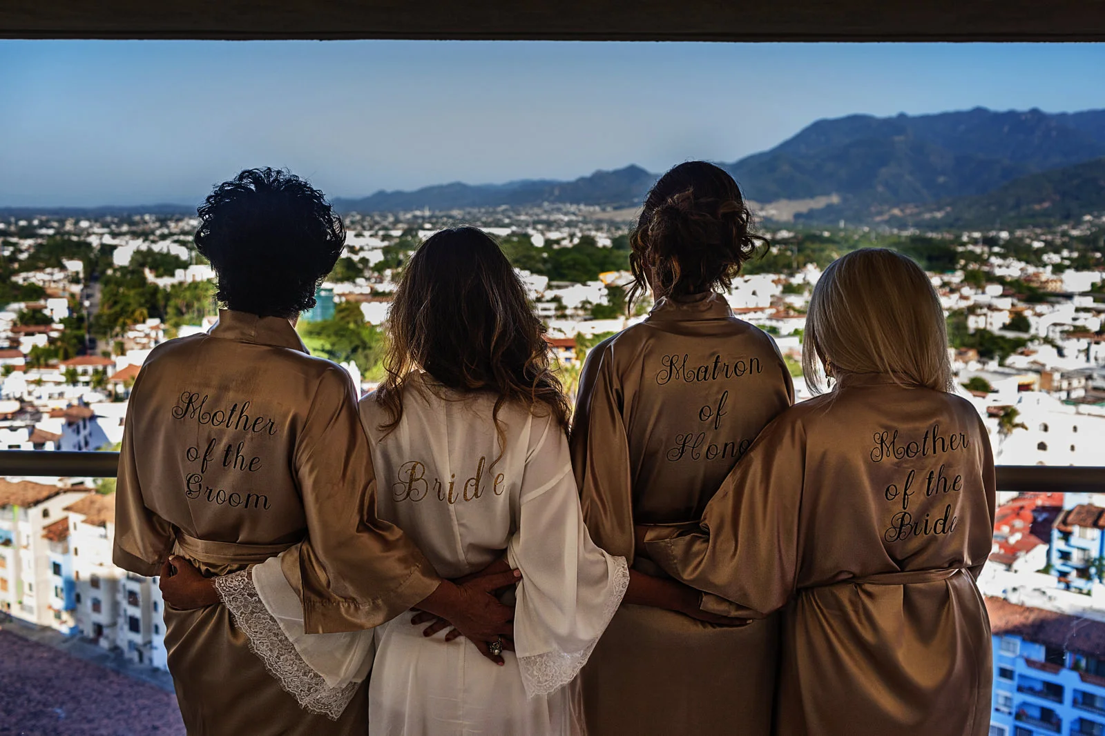 Mothers, matron of honor and bride showing their ropes against a view of Puerto Vallarta