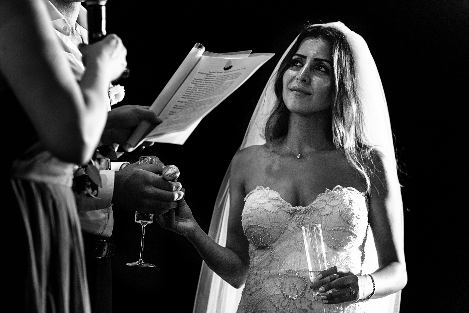 Bride looking at her mom during a speech while the groom holds her hand