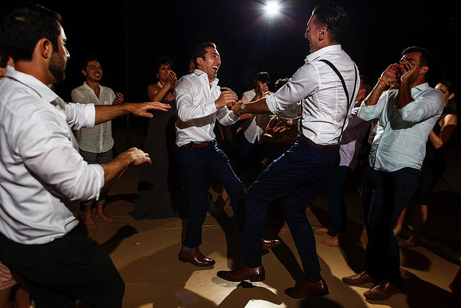 Groom and best-man dancing in one leg at the wedding party