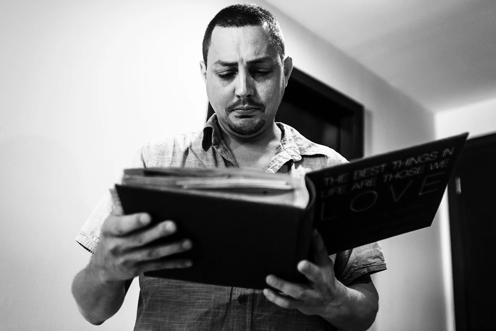 Groom looking at the scrap book that his bride made for him