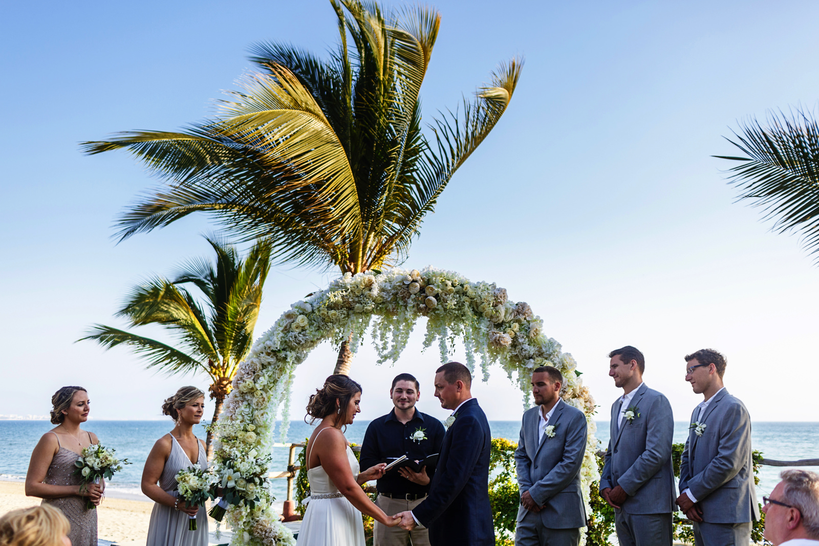 Bride reads her vows during the wedding ceremony with the ocean in the background