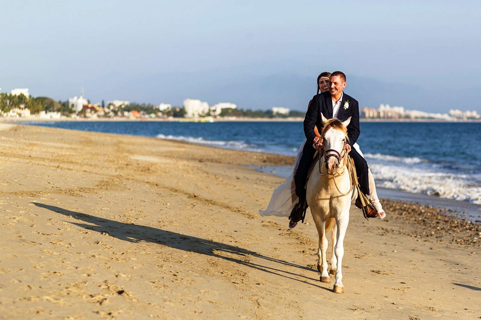 Bride and groom horse backridding on the beach
