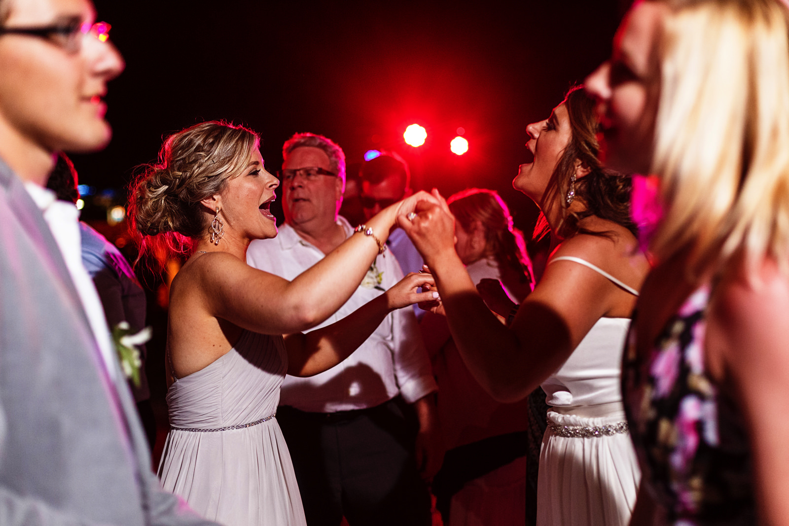 Bride and sister dancing and singing at the dancefloor
