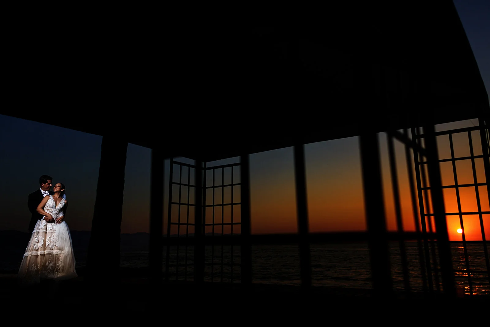 Bride and groom against the romantic mexican sunset with a game of silhouette geometry