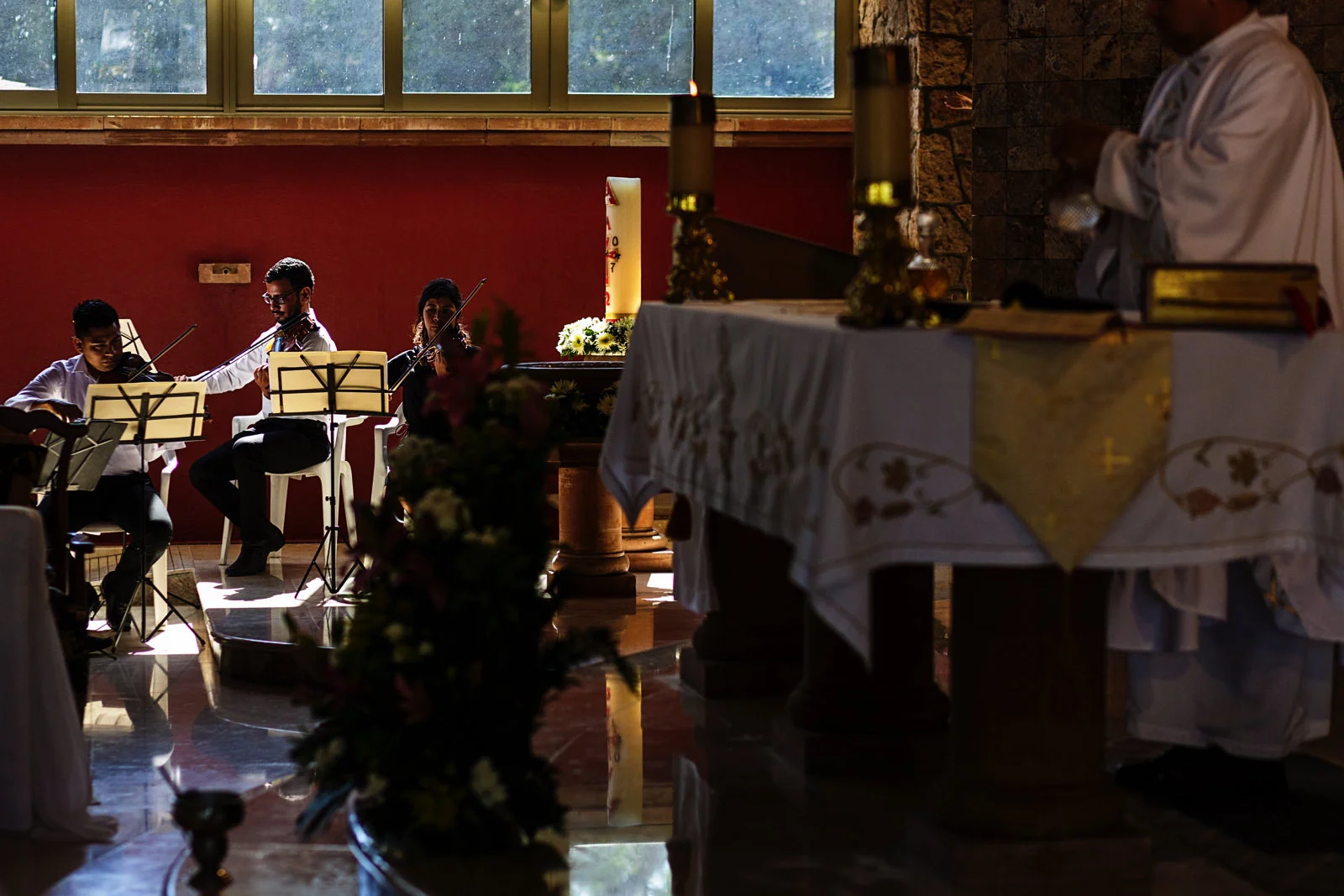 Strings trio plays during catholic wedding ceremony at church