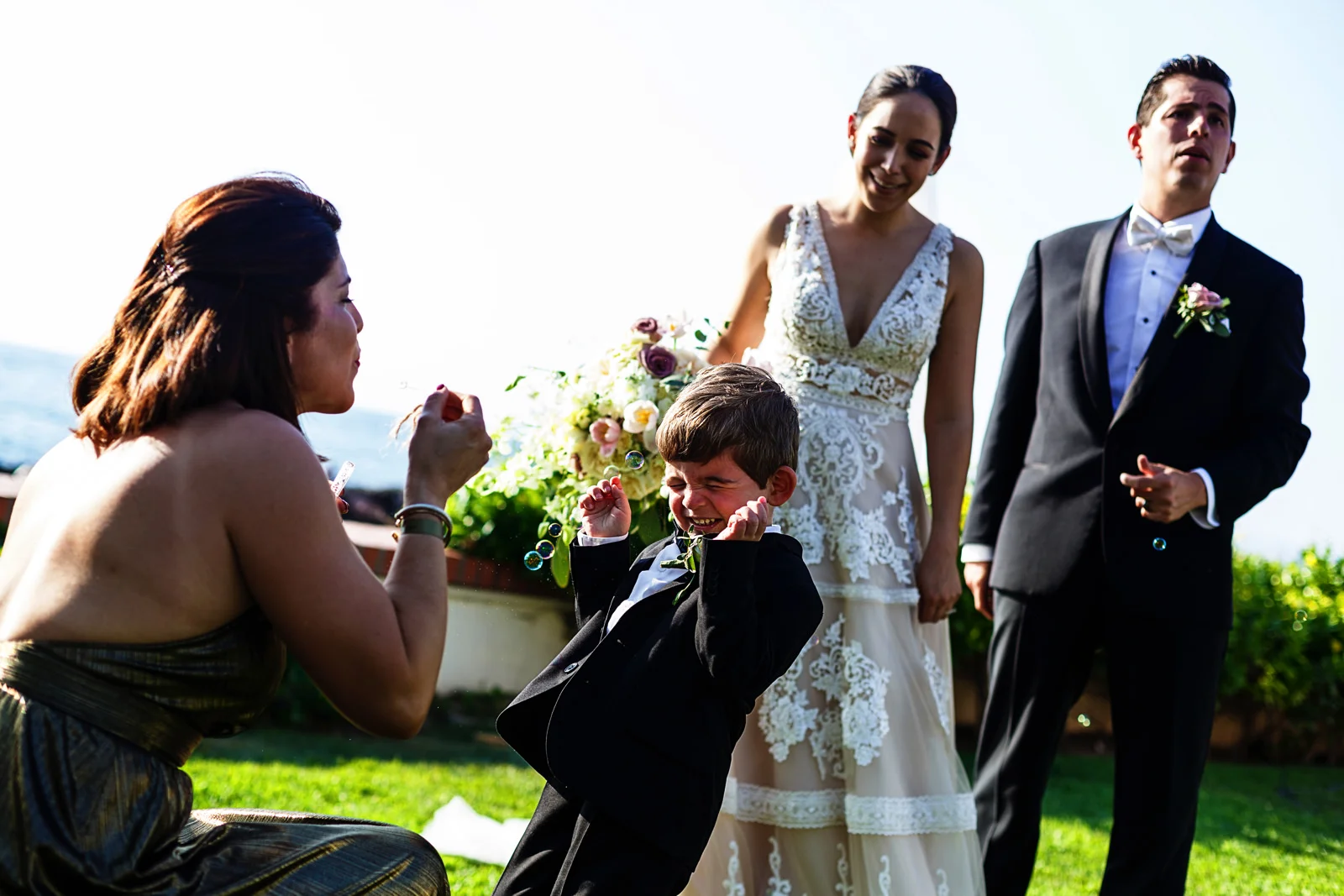 Kid reacts to bubbles being blowed at him in front of the groom and bride