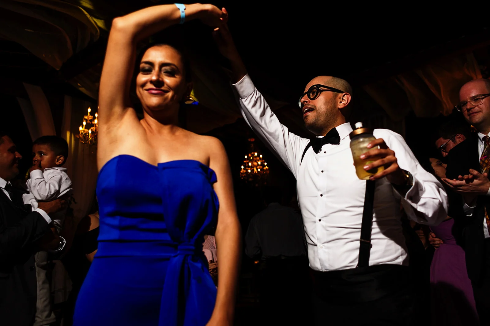 Guests dance and spin at the dance floor of the wedding party