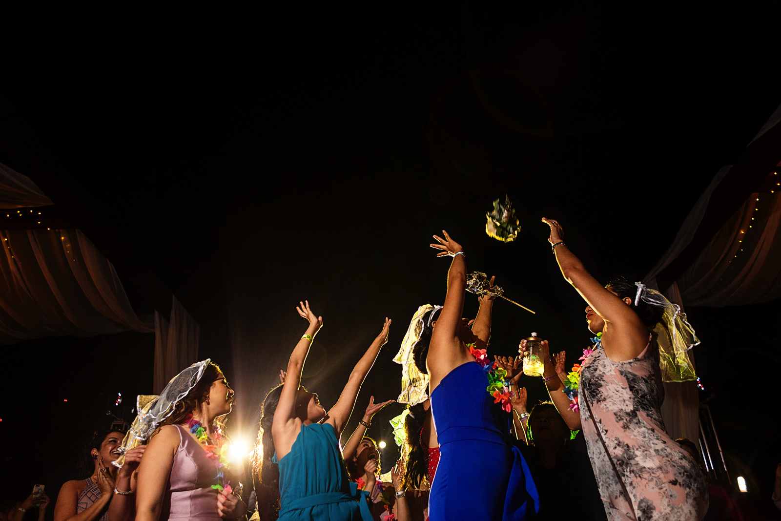 Girls trying to catch the bouquet at the wedding party