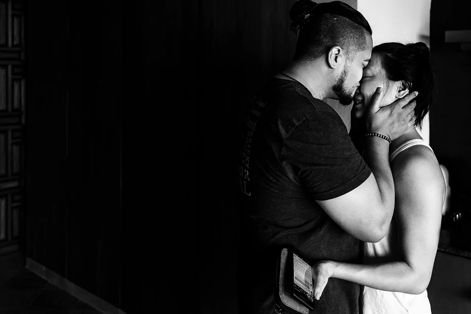 Groom kisses his bride in the room to start their wedding day preparations