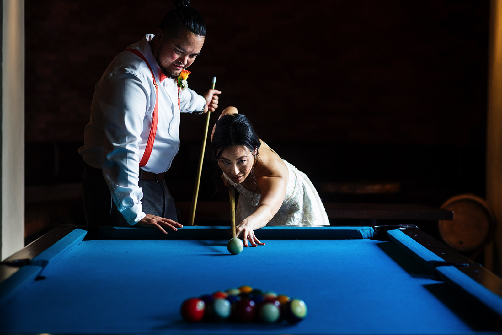 Bride and groom playing table pool